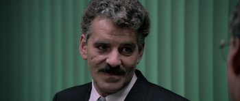 Movie still from “Manhunter” (1986), directed by Michael Mann – A person wearing a suit and tie; Close Up shot, Low angle