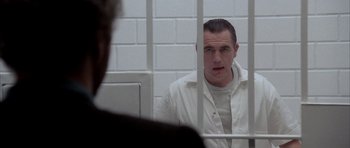 Movie still from “Manhunter” (1986), directed by Michael Mann – A man in a jail cell looking at another man in jail; Close Up shot, Over the shoulder angle