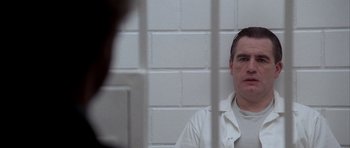 Movie still from “Manhunter” (1986), directed by Michael Mann – A man sitting in front of a jail cell; Close Up shot, Low angle