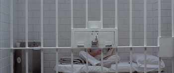 Movie still from “Manhunter” (1986), directed by Michael Mann – A jail cell with a person in it; Wide shot, Overhead angle