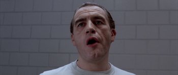 Movie still from “Manhunter” (1986), directed by Michael Mann – A person in a prison cell; Close Up shot, Low angle