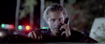 Movie still from “Manhunter” (1986), directed by Michael Mann – A man is talking on a cell phone; Close Up shot, Low angle