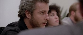 Movie still from “Manhunter” (1986), directed by Michael Mann – A person with curly hair and a beard; Close Up shot, Over the shoulder angle