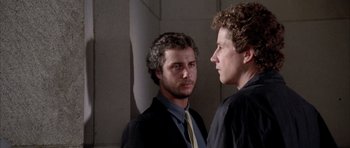 Movie still from “Manhunter” (1986), directed by Michael Mann – Two men in suits looking into each other's eyes; Close Up shot, Over the shoulder angle