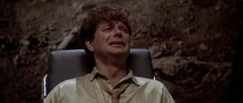 Movie still from “Manhunter” (1986), directed by Michael Mann – A man sitting in a chair with his eyes closed; Close Up shot, Overhead angle