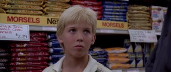 Movie still from “Manhunter” (1986), directed by Michael Mann – A young boy standing in front of a shelf of food; Close Up shot, Low angle