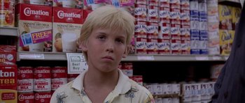 Movie still from “Manhunter” (1986), directed by Michael Mann – A young blond haired boy standing in front of a wall of cereal boxes; Close Up shot, Over the shoulder angle