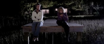 Movie still from “Manhunter” (1986), directed by Michael Mann – A man and a woman sitting next to each other on a bench; Wide shot, Low angle