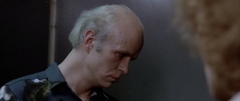 Movie still from “Manhunter” (1986), directed by Michael Mann – A man with a bald head is looking to his left; Close Up shot, Low angle