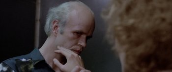Movie still from “Manhunter” (1986), directed by Michael Mann – A man with a bald head looking in the mirror; Close Up shot, Over the shoulder angle