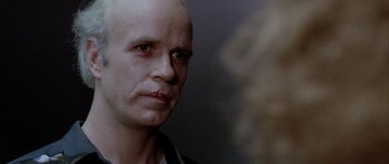 Movie still from “Manhunter” (1986), directed by Michael Mann – A man with a bald head is looking at the camera; Close Up shot, Over the shoulder angle