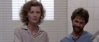 Movie still from “Manhunter” (1986), directed by Michael Mann – A woman standing next to a man in front of a window; Close Up shot, Over the shoulder angle