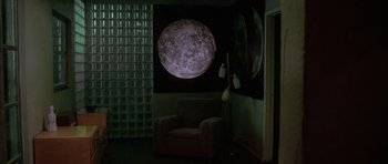 Movie still from “Manhunter” (1986), directed by Michael Mann – A room that has a chair in it and a lamp in it; Wide shot, High angle