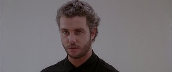Movie still from “Manhunter” (1986), directed by Michael Mann – A person wearing a black shirt; Close Up shot, Low angle