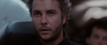 Movie still from “Manhunter” (1986), directed by Michael Mann – A person wearing a black shirt; Close Up shot, Low angle