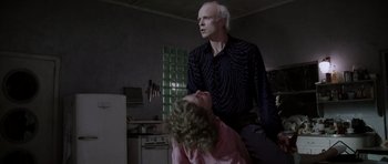Movie still from “Manhunter” (1986), directed by Michael Mann – An older man and a young girl in a kitchen; Medium shot, Low angle