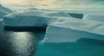 Movie still from “March of the Penguins” (2005), directed by Luc Jacquet – An aerial view of a body of water and a body of ice; Extreme Wide shot, High angle