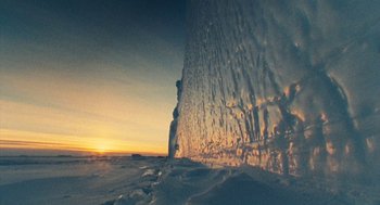 Movie still from “March of the Penguins” (2005), directed by Luc Jacquet – The sun is setting over a frozen lake; Extreme Wide shot, Low angle