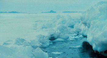 Movie still from “March of the Penguins” (2005), directed by Luc Jacquet – A large amount of ice floating in the ocean; Extreme Wide shot, High angle