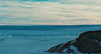 Movie still from “March of the Penguins” (2005), directed by Luc Jacquet – A view of the ocean from the top of a hill; Extreme Wide shot, High angle