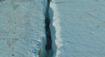 Movie still from “March of the Penguins” (2005), directed by Luc Jacquet – A view of a stream of water on a snowy surface; Extreme Wide shot, Overhead angle
