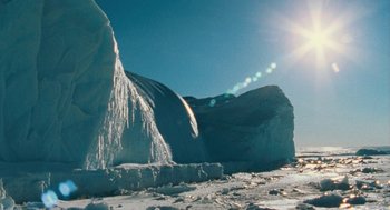 Movie still from “March of the Penguins” (2005), directed by Luc Jacquet – The sun is shining over a mountain of ice; Extreme Wide shot, Low angle