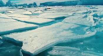 Movie still from “March of the Penguins” (2005), directed by Luc Jacquet – A view of a frozen body of water; Extreme Wide shot, High angle