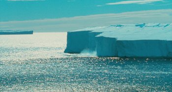 Movie still from “March of the Penguins” (2005), directed by Luc Jacquet – A very large block of ice floating in the ocean; Extreme Wide shot, High angle