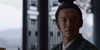 Movie still from “Marco Polo” (2014), created by John Fusco – A man in a green and white shirt with a black hat; Close Up shot, Low angle