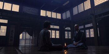 Movie still from “Marco Polo” (2014), created by John Fusco – Two people sitting in a room with a candle; Wide shot, Over the shoulder angle
