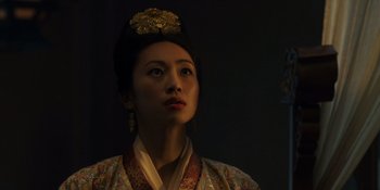 A woman wearing a traditional chinese dress and a gold headpiece