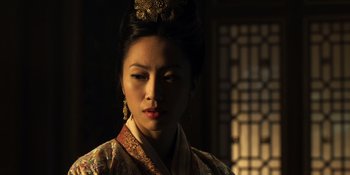 Movie still from “Marco Polo” (2014), created by John Fusco – A woman wearing a traditional chinese dress and a gold tiara; Close Up shot, Over the shoulder angle