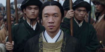 Movie still from “Marco Polo” (2014), created by John Fusco – A man in traditional chinese clothing with other men in the background; Close Up shot, Over the shoulder angle