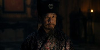 Movie still from “Marco Polo” (2014), created by John Fusco – A man with long black hair and a beard wearing a hat; Close Up shot, Low angle