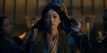 Movie still from “Marco Polo” (2014), created by John Fusco – A woman in a traditional chinese costume is putting a hat on; Close Up shot, Low angle