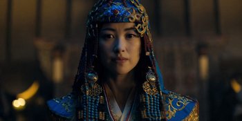 Movie still from “Marco Polo” (2014), created by John Fusco – A woman wearing a blue and gold headdress; Close Up shot, Low angle