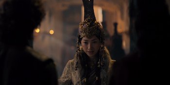 Movie still from “Marco Polo” (2014), created by John Fusco – A woman wearing a headdress and a white dress; Close Up shot, Over the shoulder angle