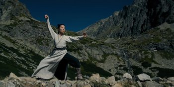 Movie still from “Marco Polo” (2014), created by John Fusco – A woman in a long white coat standing on a rock; Medium shot, Low angle