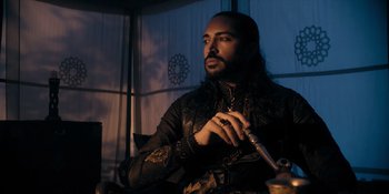 Movie still from “Marco Polo” (2014), created by John Fusco – A man with long hair is holding a smoking pipe; Medium shot, Low angle
