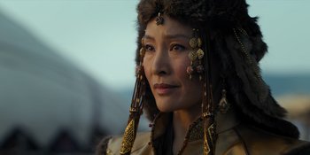 Movie still from “Marco Polo” (2014), created by John Fusco – A person wearing a hat and earrings; Close Up shot, Over the shoulder angle