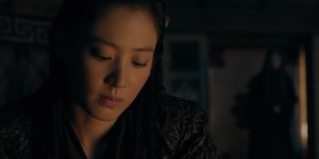 Movie still from “Marco Polo” (2014), created by John Fusco – A young woman with long braids is looking down; Close Up shot, High angle