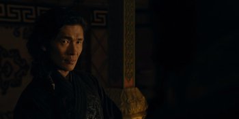 Movie still from “Marco Polo” (2014), created by John Fusco – A man standing in front of a pillar in a dark room; Close Up shot, Over the shoulder angle