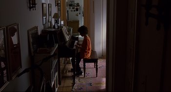 Movie still from “Margaret” (2011), directed by Kenneth Lonergan – A young girl sitting at a piano in a living room; Wide shot, High angle