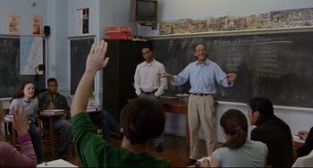 Movie still from “Margaret” (2011), directed by Kenneth Lonergan – A group of people standing in front of chalkboards; Medium shot, Over the shoulder angle