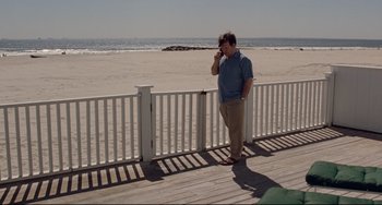 Movie still from “Margaret” (2011), directed by Kenneth Lonergan – A man standing on a boardwalk talking on a cell phone; Wide shot, High angle