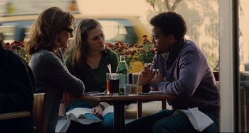 Movie still from “Margaret” (2011), directed by Kenneth Lonergan – A group of people sitting at a table with drinks; Medium shot, Over the shoulder angle