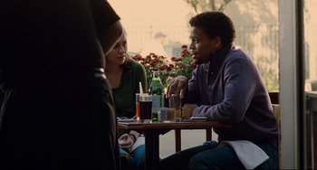 Movie still from “Margaret” (2011), directed by Kenneth Lonergan – A man and a woman sitting at a table with drinks on it; Medium shot, Over the shoulder angle