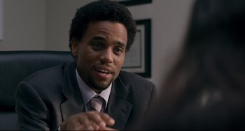 Movie still from “Margaret” (2011), directed by Kenneth Lonergan – A man wearing a suit and tie talking to someone; Close Up shot, Over the shoulder angle