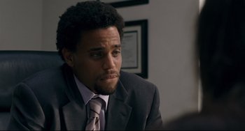 Movie still from “Margaret” (2011), directed by Kenneth Lonergan – A man wearing a suit and tie sitting in front of a mirror; Close Up shot, Over the shoulder angle