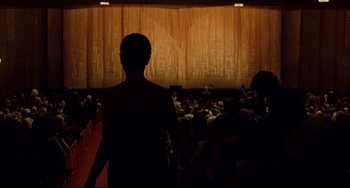 Movie still from “Margaret” (2011), directed by Kenneth Lonergan – A man standing in front of an audience in a theater; Extreme Wide shot, Low angle